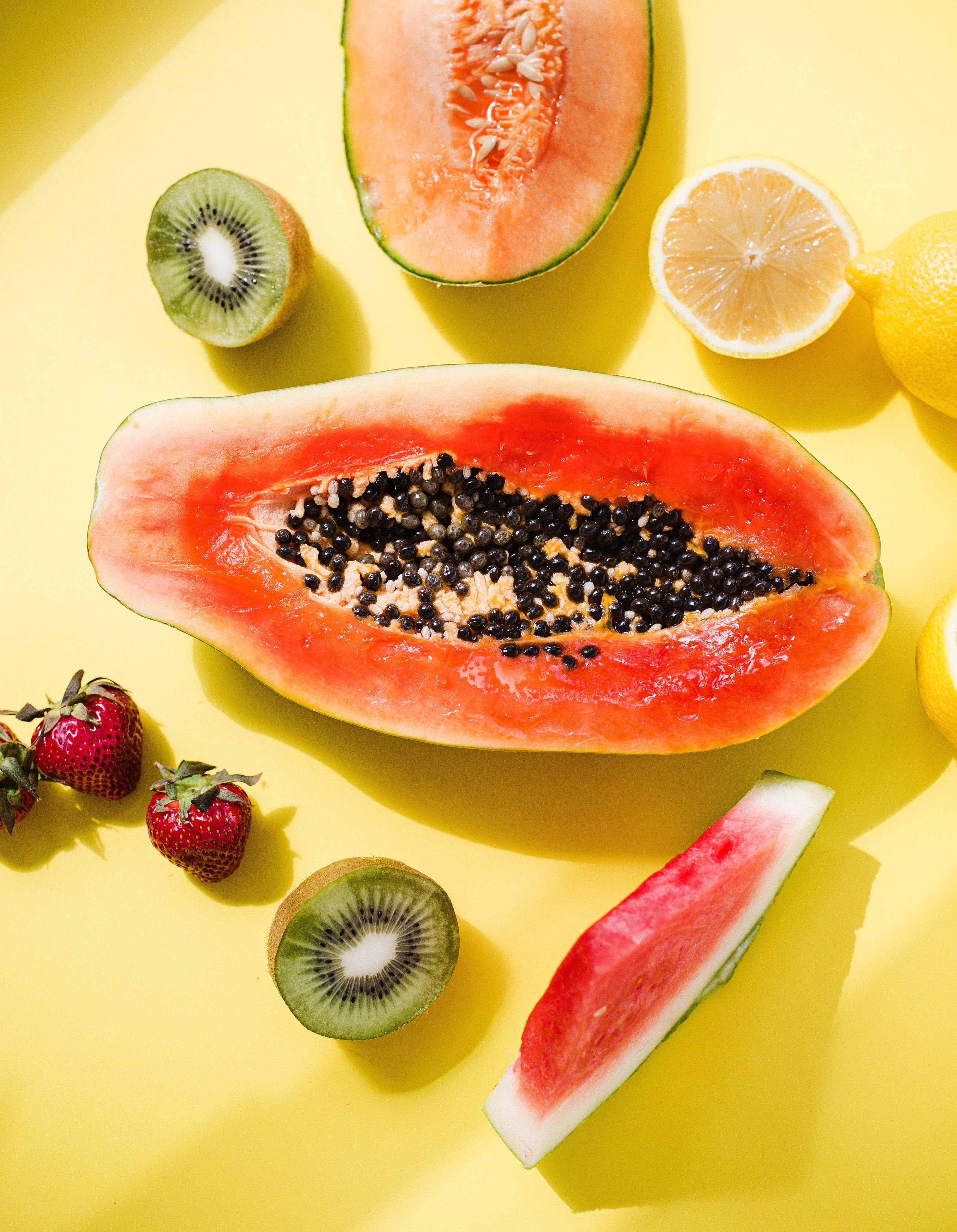 files/a-papaya-is-surrounded-by-fruit-on-yellow-background.jpg